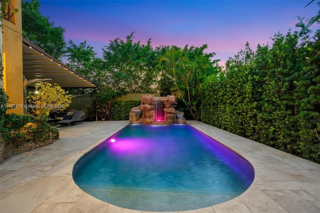 pool at dusk featuring a patio area