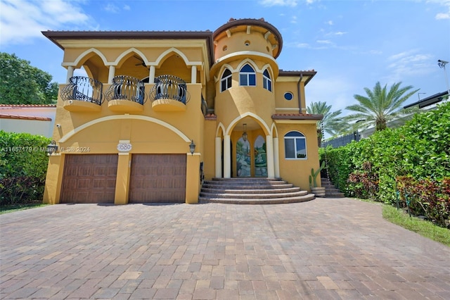 9580 Byron Ave, Surfside, FL 33154 - mediterranean / spanish-style home featuring a balcony, french doors, stucco siding, an attached garage, and driveway
