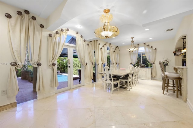 dining space featuring french doors and a chandelier