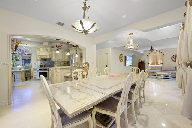 9580 Byron Ave, Surfside, FL 33154 - dining space featuring a chandelier, arched walkways, and ceiling fan