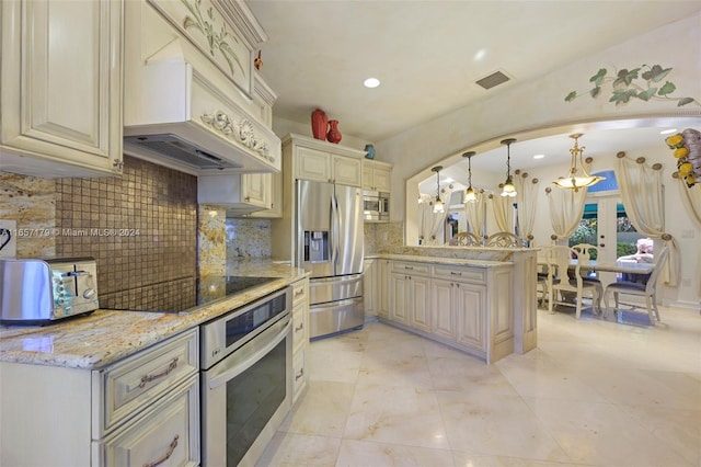 kitchen featuring hanging light fixtures, backsplash, a chandelier, cream cabinetry, and appliances with stainless steel finishes