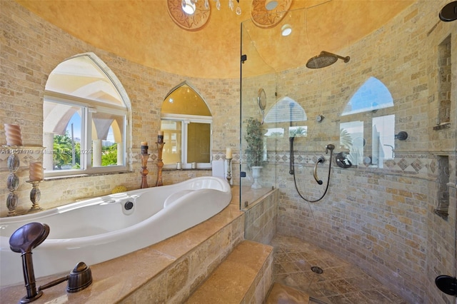 bathroom with shower with separate bathtub and tile walls