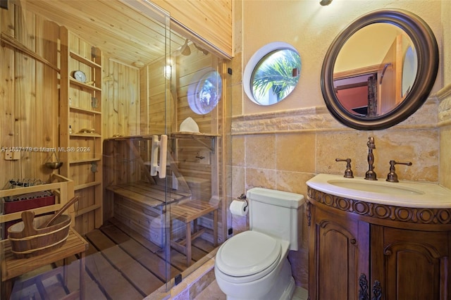 bathroom featuring tile walls, vanity, and toilet