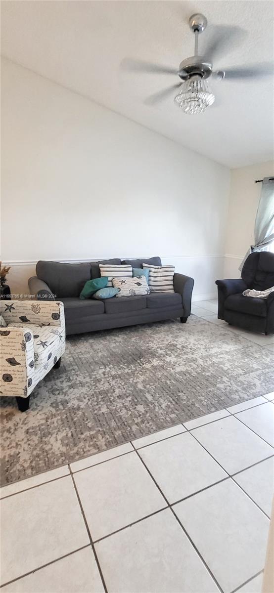 living room with ceiling fan and tile patterned floors