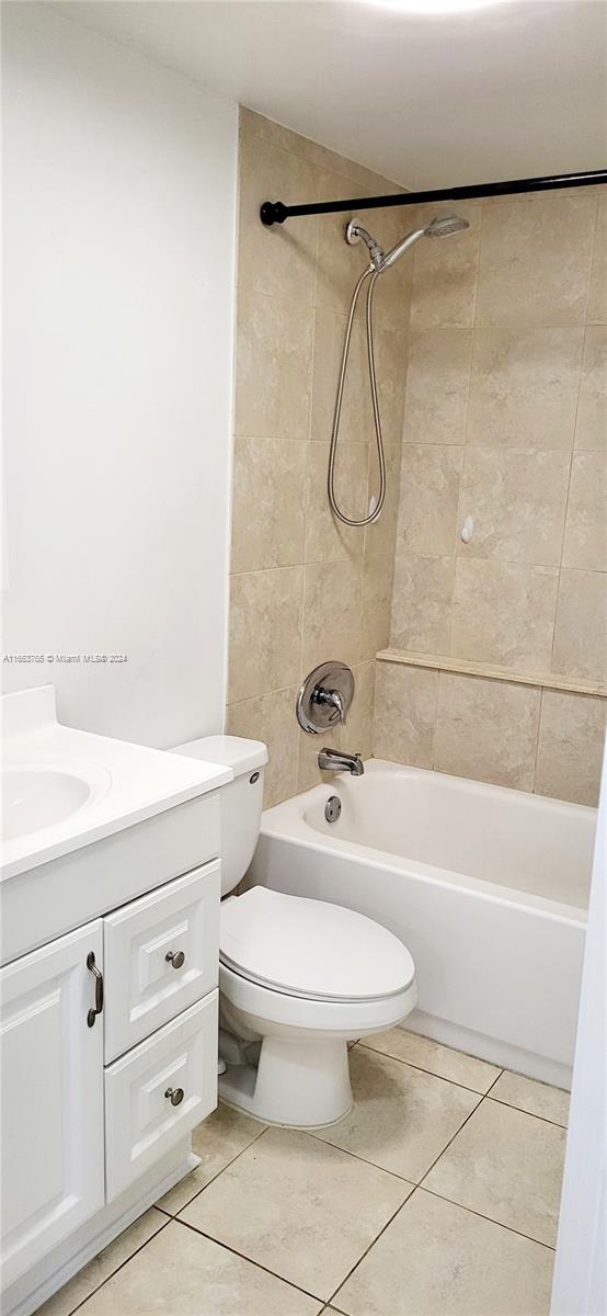 full bathroom with vanity, tiled shower / bath combo, toilet, and tile patterned flooring