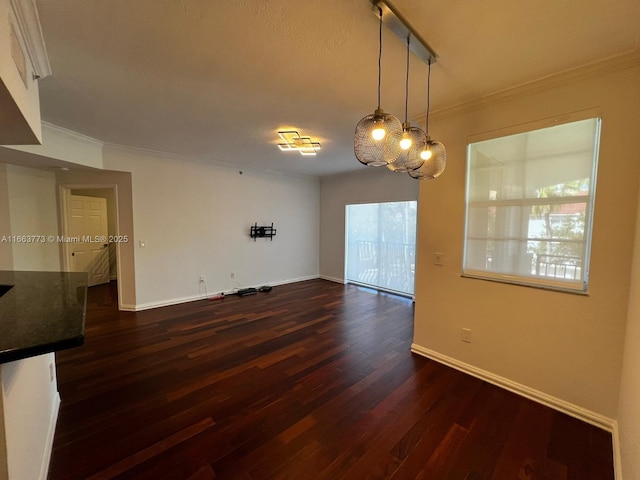 spare room with dark wood-type flooring, track lighting, and ornamental molding