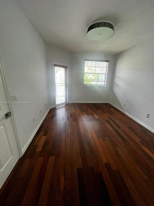 unfurnished room featuring dark wood-type flooring