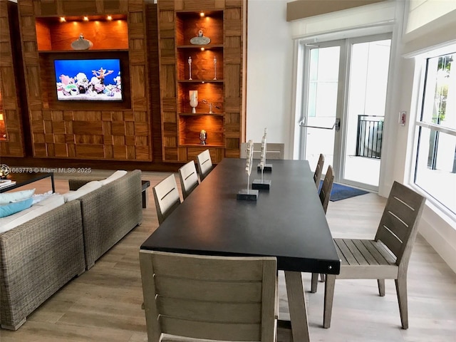 dining space featuring built in shelves and light hardwood / wood-style floors