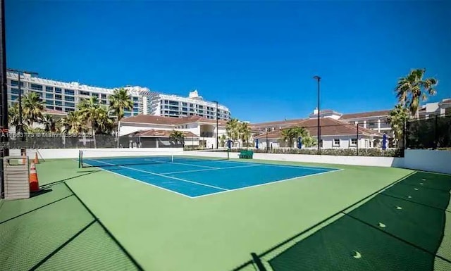 view of tennis court with basketball hoop