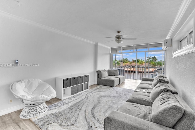 living room with baseboards, ceiling fan, ornamental molding, wood finished floors, and a water view