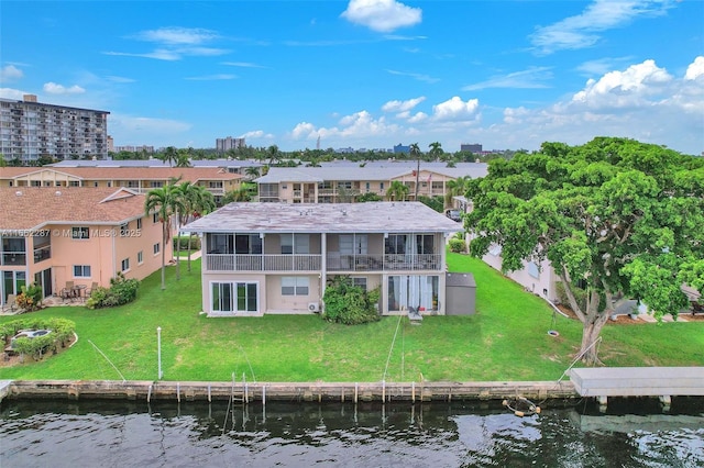 back of property featuring a water view, a sunroom, and a lawn