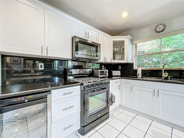 kitchen featuring stainless steel appliances, backsplash, sink, and white cabinetry