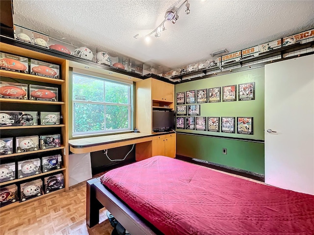 bedroom featuring a textured ceiling and light parquet flooring