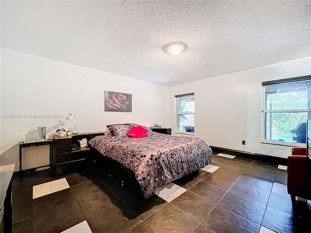 tiled bedroom featuring a textured ceiling