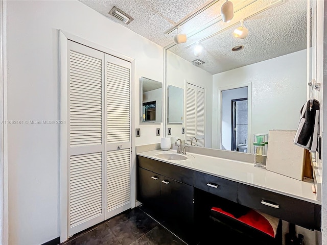 bathroom featuring vanity, a textured ceiling, and tile patterned floors