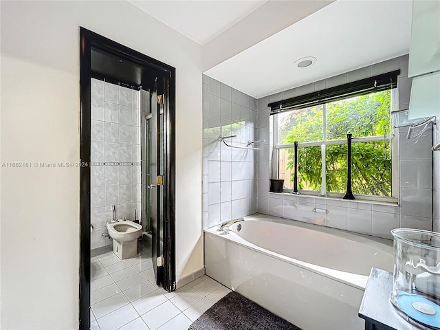 bathroom featuring vanity, a bathtub, a bidet, tile walls, and tile patterned flooring