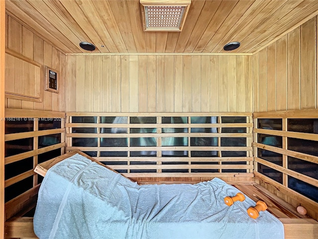 bedroom with wood-type flooring, wooden walls, and wooden ceiling