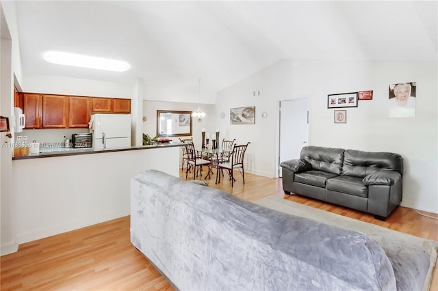 living room featuring lofted ceiling and light hardwood / wood-style flooring