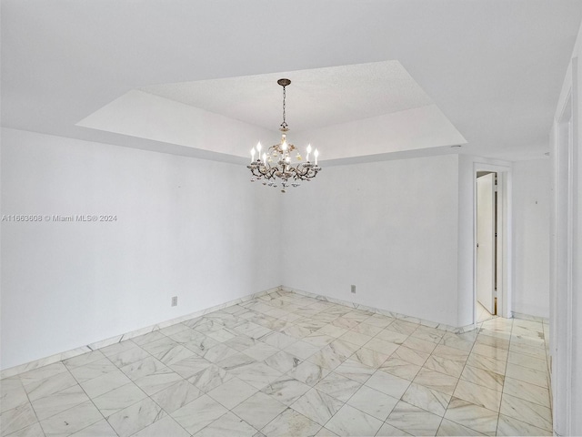 spare room featuring a chandelier