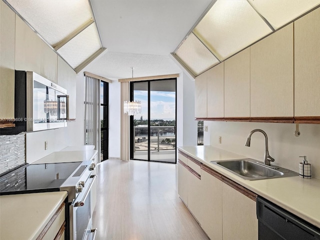 kitchen featuring cream cabinets, sink, light hardwood / wood-style flooring, and stainless steel appliances