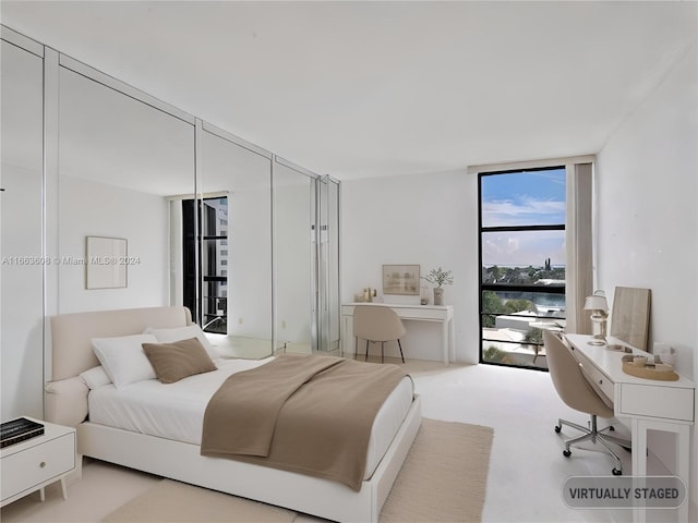 carpeted bedroom featuring floor to ceiling windows and a water view