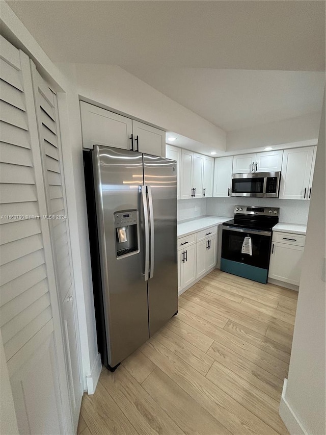 kitchen featuring appliances with stainless steel finishes, light wood-type flooring, and white cabinetry