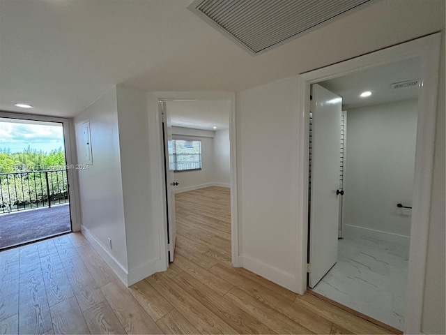 kitchen with appliances with stainless steel finishes, light stone counters, sink, white cabinets, and light hardwood / wood-style floors