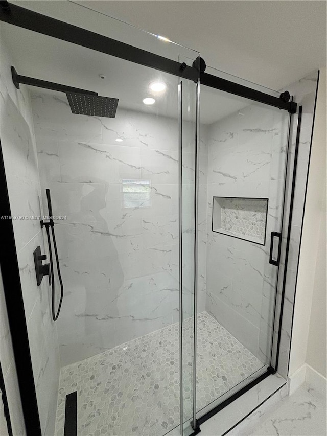 bathroom with a shower with door