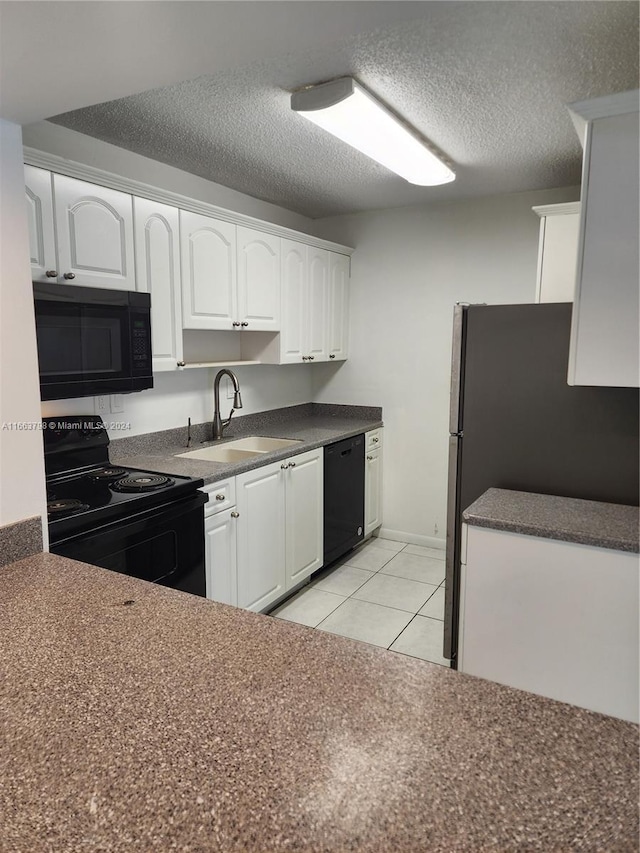 kitchen with sink, white cabinets, black appliances, and light tile patterned floors