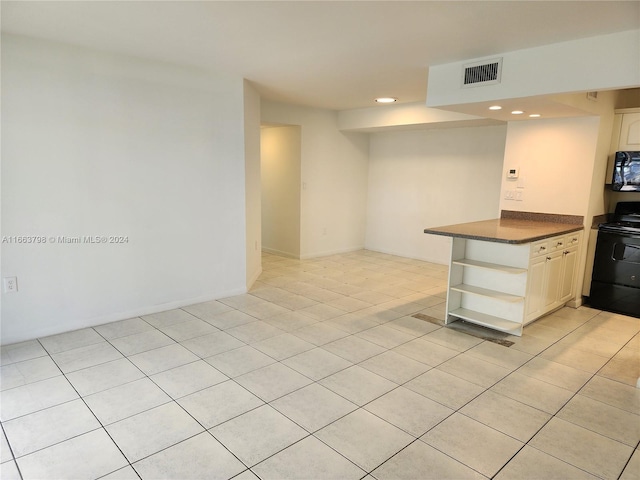 kitchen featuring kitchen peninsula, light tile patterned floors, and black appliances