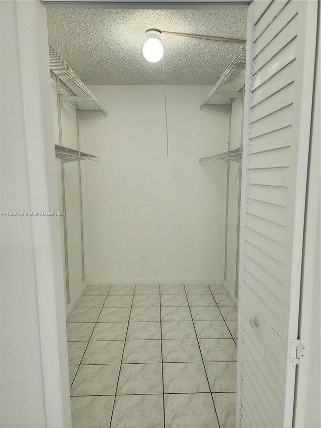 walk in closet featuring light tile patterned flooring