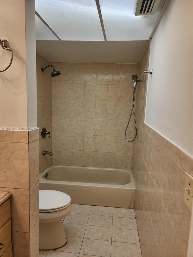 full bathroom with tile patterned floors, vanity, toilet, and tile walls