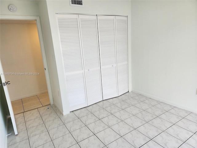 unfurnished bedroom featuring a closet and light tile patterned floors