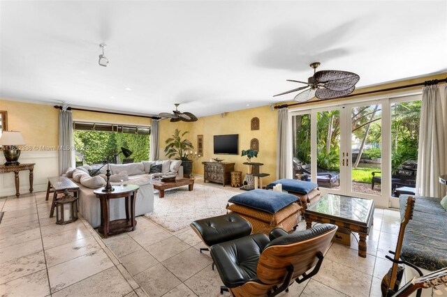 living room featuring plenty of natural light, ceiling fan, and french doors