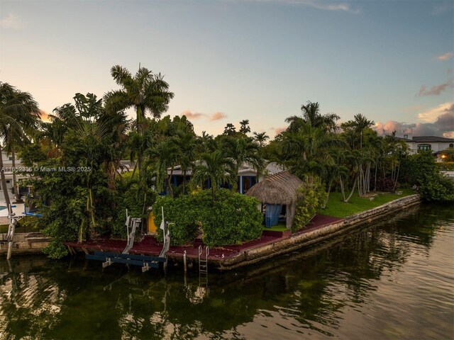 back house at dusk featuring a water view