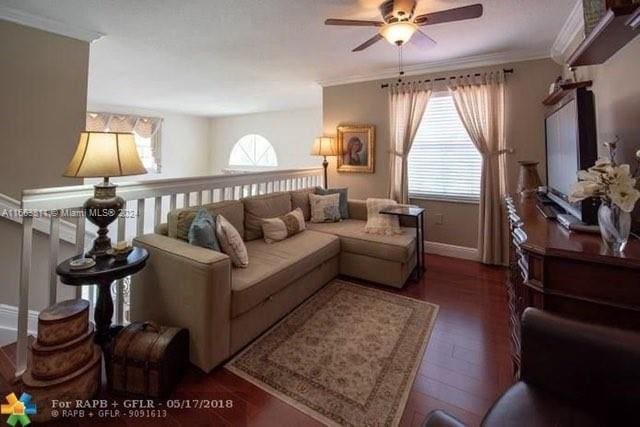 living room featuring ceiling fan, ornamental molding, dark hardwood / wood-style flooring, and a healthy amount of sunlight