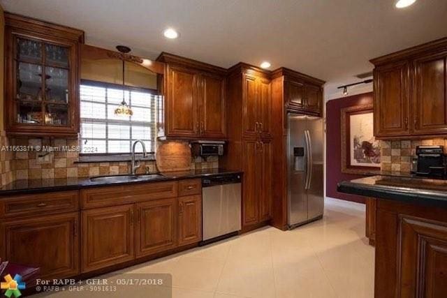 kitchen with decorative backsplash, appliances with stainless steel finishes, light tile patterned flooring, and sink