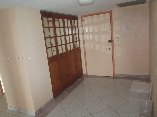 interior space featuring a textured ceiling and light tile patterned floors