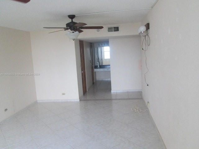 tiled spare room featuring ceiling fan