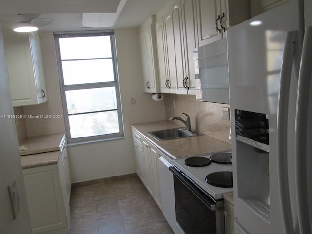 kitchen with sink, white cabinets, decorative backsplash, and white appliances