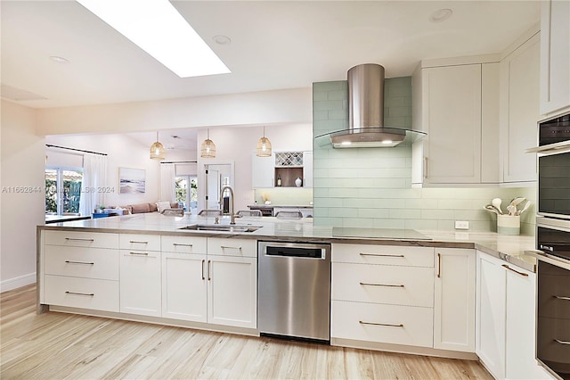 kitchen with white cabinets, sink, wall chimney range hood, and stainless steel appliances