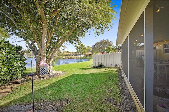 view of yard featuring a water view and a sunroom