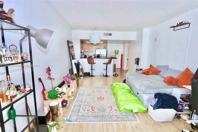 bedroom with white refrigerator with ice dispenser and wood-type flooring