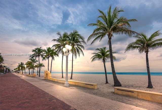 surrounding community featuring a water view and a beach view