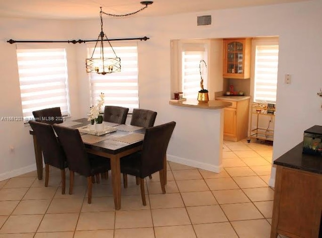 dining room with light tile patterned floors, visible vents, and a healthy amount of sunlight