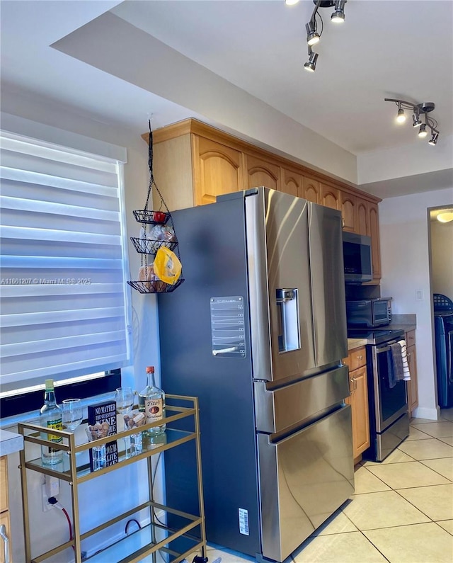 kitchen featuring light tile patterned floors, rail lighting, appliances with stainless steel finishes, and light countertops