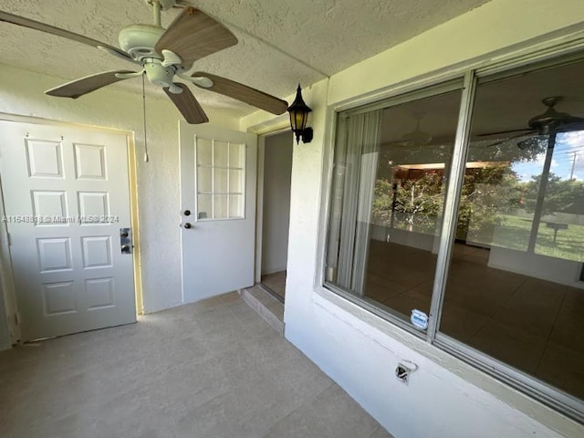view of exterior entry with a ceiling fan