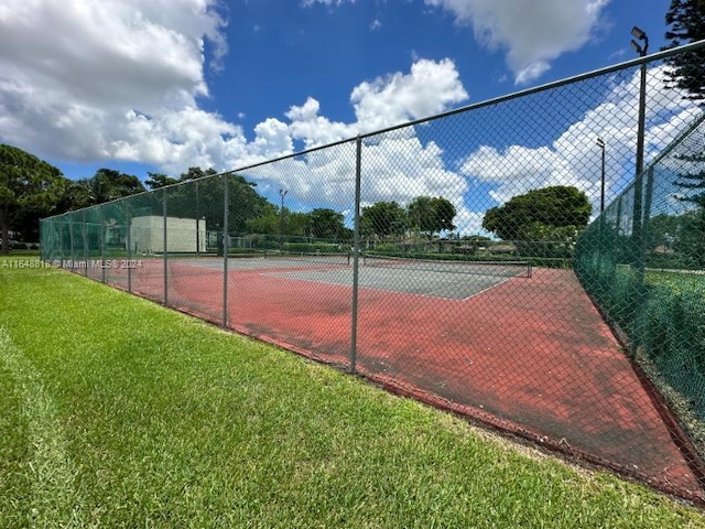 view of tennis court featuring a lawn