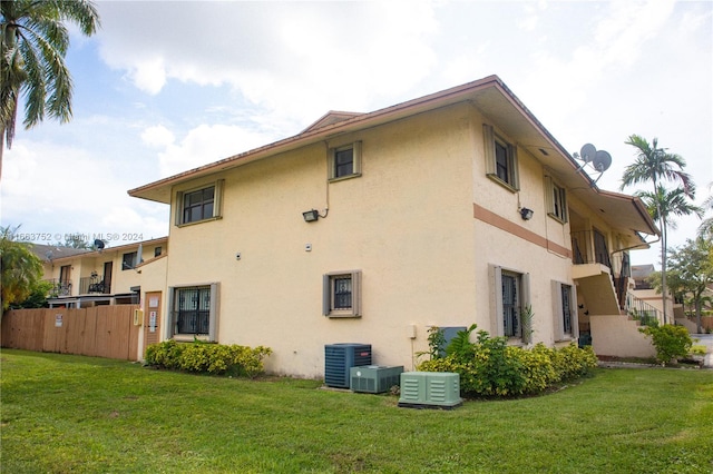 view of side of home featuring a lawn and central AC unit