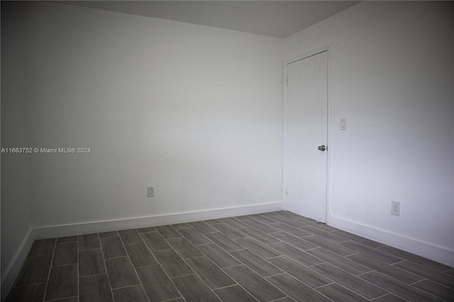 unfurnished room with dark wood-type flooring